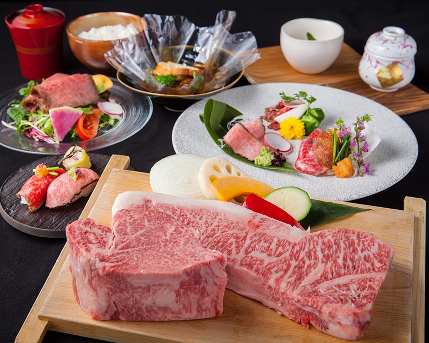 神戸牛の塊肉を中心に、前菜・お造り・肉寿司・土鍋ご飯が並ぶコースの一式